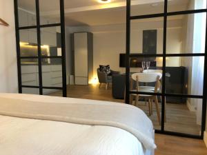 a bedroom with a bed and a table and a chair at Appartements Les Rochelais in La Rochelle