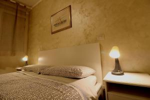 ein Schlafzimmer mit einem Bett und zwei Lampen auf einem Tisch in der Unterkunft La casa del Darda 3 in Ancona