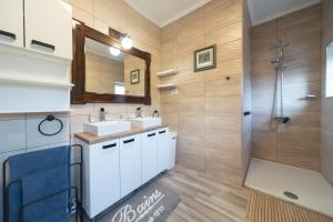 a bathroom with two sinks and a shower at Apartman Komfor Premium in Subotica