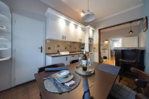 a kitchen and a dining room with a table and chairs at Apartman Komfor Premium in Subotica