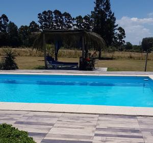 a large blue swimming pool with a gazebo at Marinas del Riachuelo in Riachuelo