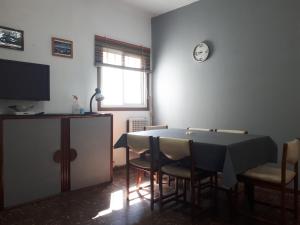 een eetkamer met een tafel, stoelen en een klok bij Departamento 2 ambientes en MIRAMAR in Miramar