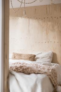 een slaapkamer met een bed met witte lakens en kussens bij NOYR. tiny house in Nunspeet