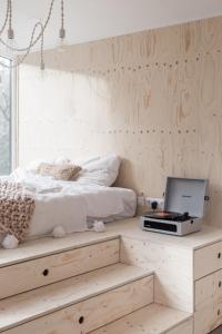 a bedroom with a bed and a laptop on a desk at NOYR. tiny house in Nunspeet