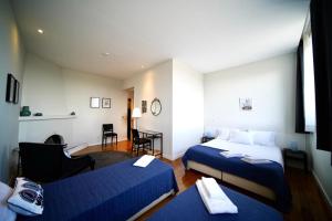 um quarto de hotel com duas camas e uma mesa e cadeiras em Burra Velha - Private House em Celorico de Basto