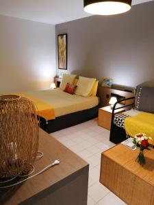 ein Hotelzimmer mit 2 Betten und einem Sofa in der Unterkunft Studio Maracudja Résidence Manganao in Saint-François