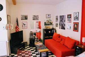ein Wohnzimmer mit einem roten Sofa und einem TV in der Unterkunft Apartmán Za kopcem in Boskovice