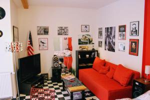 a living room with a red couch and a tv at Apartmán Za kopcem in Boskovice