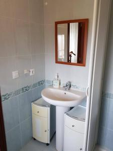 y baño con lavabo y espejo. en Vivienda Turística El Asturiano, en Montamarta