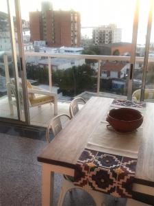 Piriapolis apartamento في بيريابوليس: طاولة خشبية مع وعاء فوق شرفة