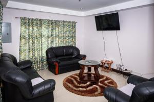 a living room with black leather chairs and a table at Nzingha's Villa in Buccoo