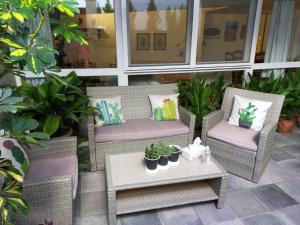 um pátio com cadeiras de vime e uma mesa com plantas em Casabobastro em Ardales