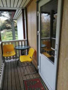 a room with a table and chairs on a porch at Apartment by the park in Imatra