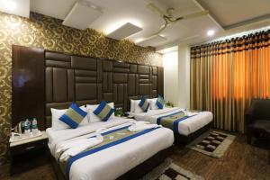ein Hotelzimmer mit 2 Betten mit blauen und weißen Kissen in der Unterkunft Hotel Mannat international by Mannat in Neu-Delhi