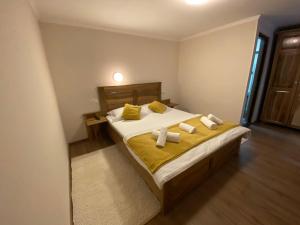 een slaapkamer met een bed met gele lakens en kussens bij Hanul Ursilor in Chişcău