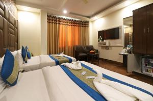 Una habitación de hotel con dos camas y un televisor. en Hotel Mannat international by Mannat, en Nueva Delhi