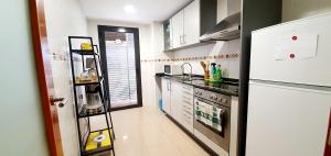 una cocina con refrigerador y estufa horno superior en Deltebre Apartamentos, en Deltebre