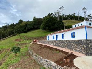 a stone retaining wall next to a white building at Casa da Bisa - Santa Maria - Açores in Santa Bárbara
