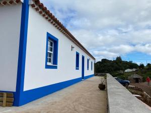 um edifício branco e azul com janelas azuis em Casa da Bisa - Santa Maria - Açores em Santa Bárbara