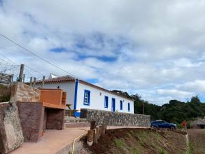 a blue and white building on a hill with a bridge at Casa da Bisa - Santa Maria - Açores in Santa Bárbara