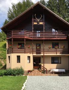 a large house with a porch and a balcony at Casa Cerbu in Arieşeni