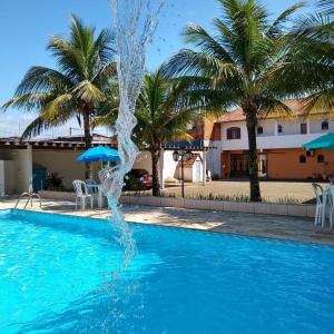 a water fountain in a pool with palm trees at San Marino Hotel in Itanhaém