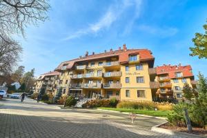 um edifício amarelo com um telhado vermelho numa rua em Willa Ogrodowa em Polanica-Zdrój