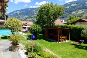 a garden with a pool and a gazebo at Ferienwohnungen Haus Christine in Rifiano