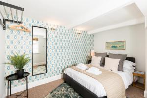 ein Schlafzimmer mit einem großen Bett und einem Spiegel in der Unterkunft Grundy's Lane Apartments in Malvern Wells
