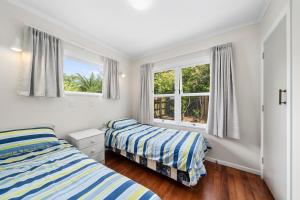 Ένα ή περισσότερα κρεβάτια σε δωμάτιο στο Blue Gate Cottage - Waikanae Beach Holiday Home