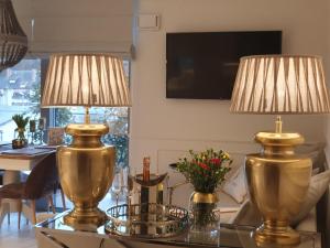 dos lámparas de oro sentadas en una mesa de cristal con un comedor en Apartament Prestige & Sea Balticus A4, en Międzyzdroje