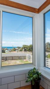 a window with a view of the ocean at Jetty's End Bicheno in Bicheno