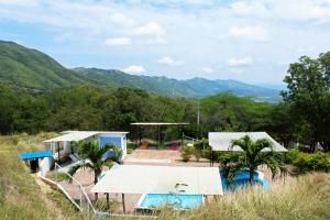 a group of buildings with mountains in the background at Girardot Cabañas - Balcón de Guabinal in El Guabinal