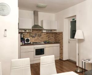 a kitchen with white cabinets and a stove top oven at Apartmani "Mimoza" in Otočac