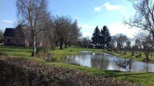 rzeka w parku z drzewami i budynek w obiekcie Le studio du Pressoir w mieście Gisay