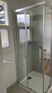 a shower with a glass door in a bathroom at Jetty's End Bicheno in Bicheno