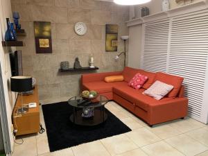 sala de estar con sofá rojo y mesa en PLAYA CHICA BEACH 1, en Santa Cruz de Tenerife