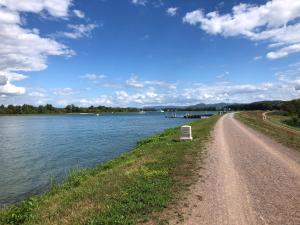 een onverharde weg naast een waterlichaam bij Appartement du Rhin in Neuhaeusel