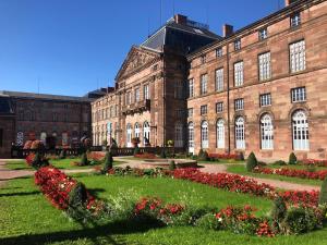 un gran edificio de ladrillo con flores delante en Appartement du Rhin en Neuhaeusel