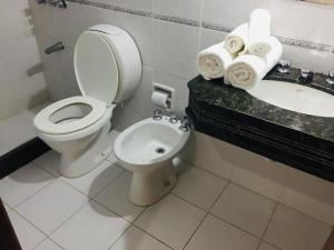 a bathroom with a toilet and a sink and towels at San Remo Terrazas Hotel in Piriápolis +50 photos