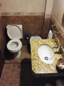 a bathroom with a white toilet and a sink at San Remo Terrazas Hotel in Piriápolis