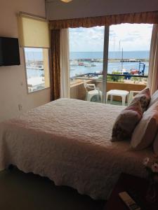 a bedroom with a large bed and a large window at San Remo Terrazas Hotel in Piriápolis