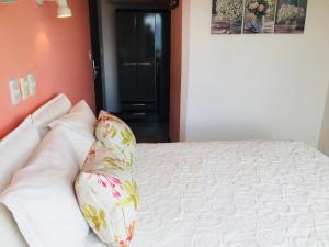 uma cama com uma almofada em cima em San Remo Terrazas Hotel em Piriápolis