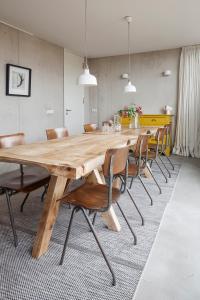 einen großen Holztisch in einem Zimmer mit Stühlen in der Unterkunft MOoij Bed en Breakfast in Ooij