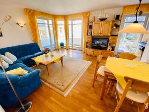 ein Wohnzimmer mit einem blauen Sofa und einem Tisch in der Unterkunft Residenz Bleichröder - Ferienwohnung 27 in Heringsdorf