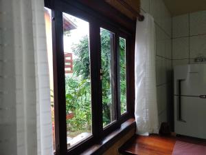 a kitchen with a window and a refrigerator in a room at CASA PRUMIRIM in Ubatuba +49 photos
