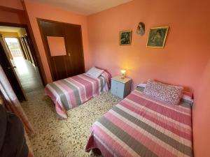 two beds in a room with pink walls at El Campo in Zaragoza