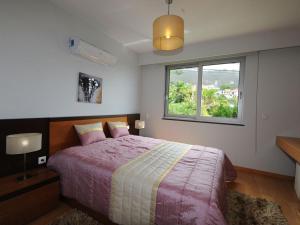 a bedroom with a large bed and a window at Blue Villa in Arco da Calheta +29 photos