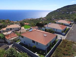eine Luftansicht eines Hauses mit rotem Dach in der Unterkunft Blue Villa in Arco da Calheta