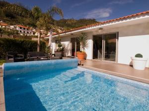 ein Swimmingpool vor einem Haus in der Unterkunft Blue Villa in Arco da Calheta